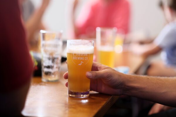 Close-up of a freshly poured craft beer from The Coastal Brewing Company in Forster, showcasing its vibrant community atmosphere and locally brewed flavors.